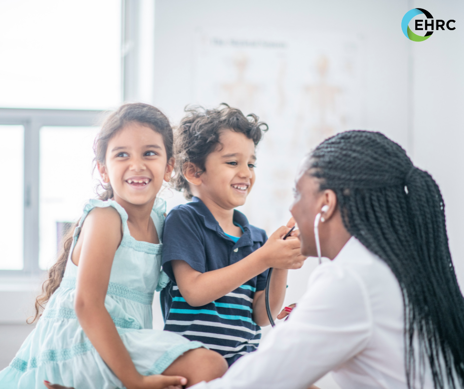 Two happy kids at the doctor's office with a pediatrician.